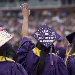 Graduation cap on person with hand up