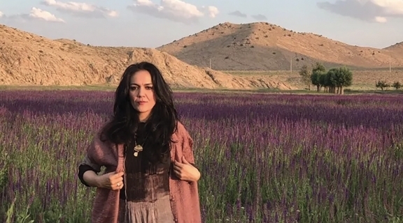 Marjan Vahdat standing in a field of purple flowers